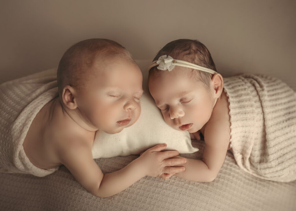 newborn twins holding hands