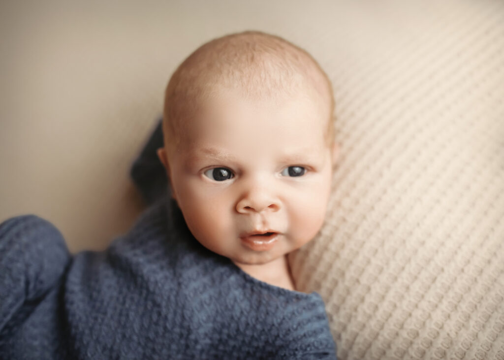 newborn session with a baby boy wearing blue