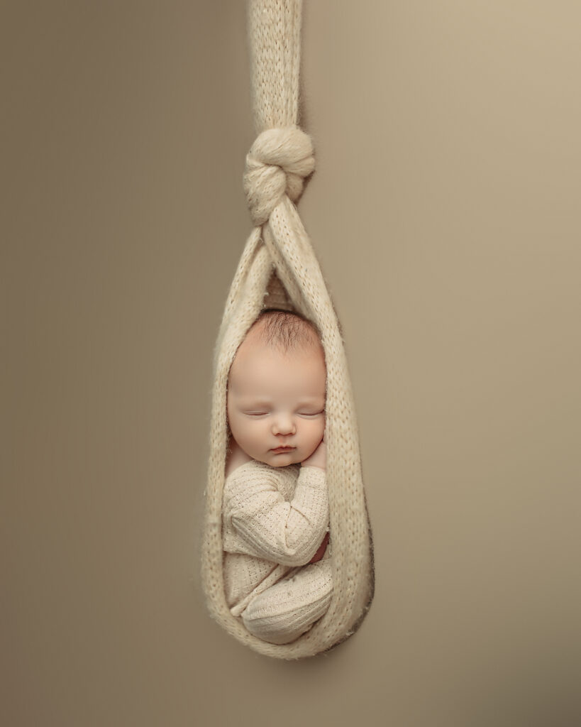 Newborn baby boy hanging in blanket
