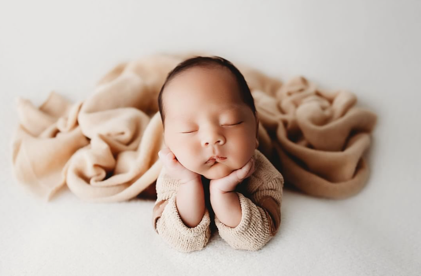 Keely Nicole Photography. Newborn baby in froggy pose with warm neutral colors.