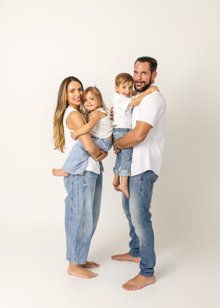 Family photo with mom, dad, and two young children wearing white and jeans. OKC Family Photography.