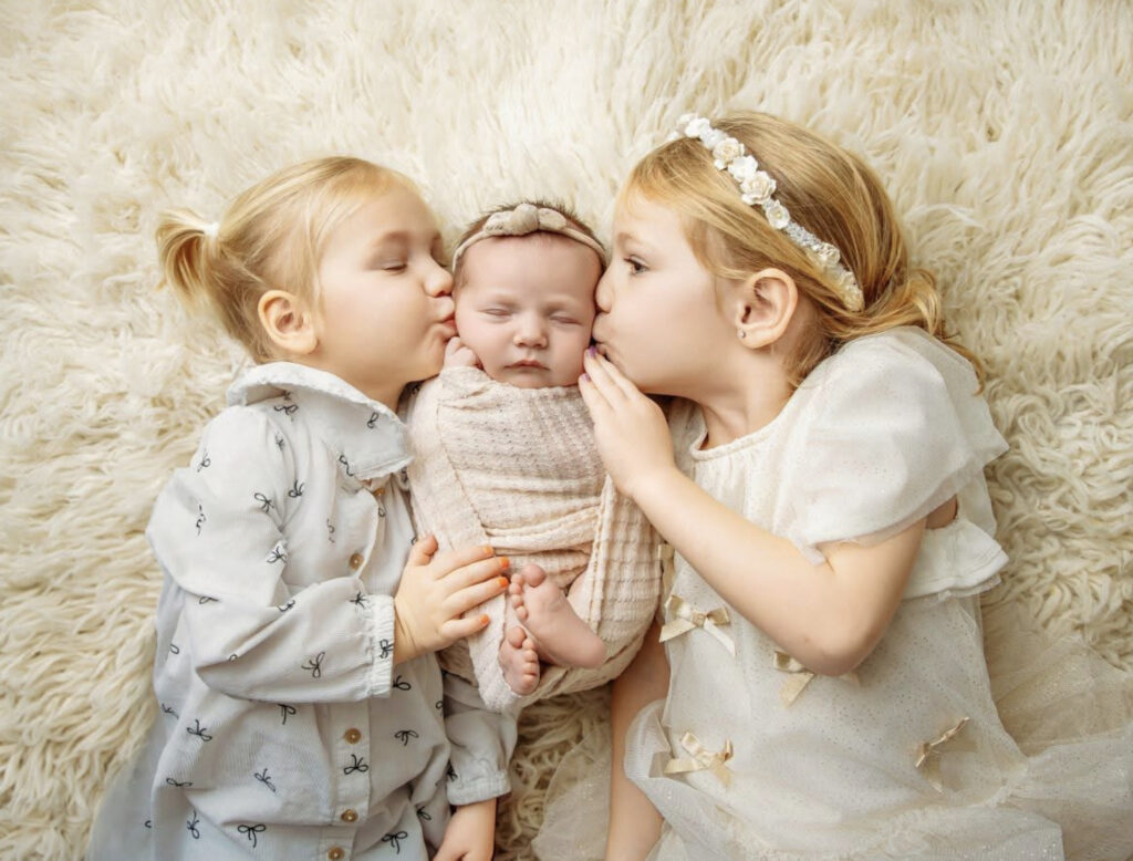 Older siblings showing affection towards their newborn sibling