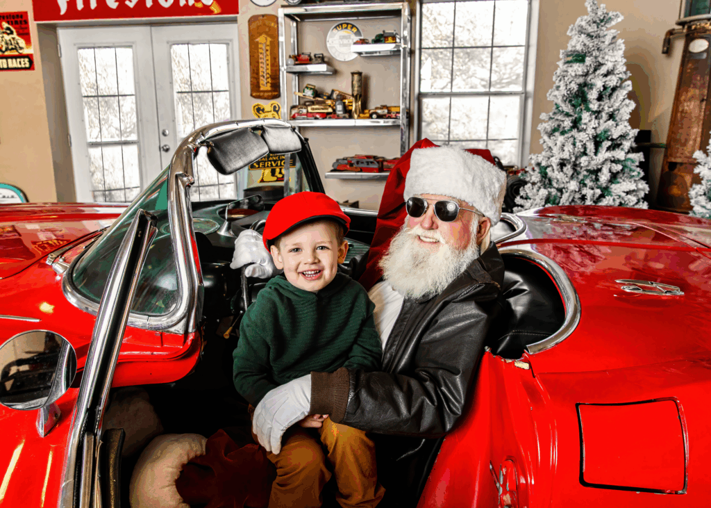 santa with little boy in corvette car during a santa photo mini session 
