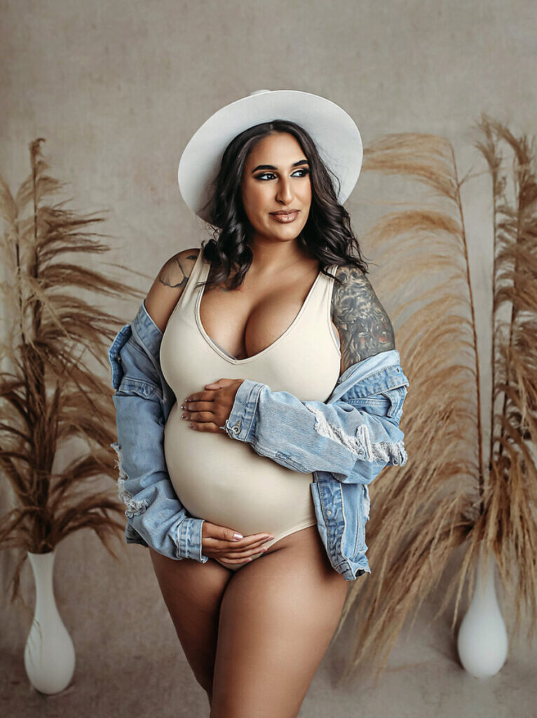 white bodysuit with white hat and jean jacket in a OKC maternity photoshoot