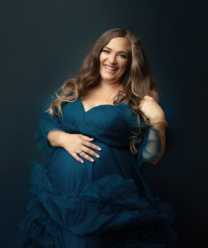 dark green gown with mother smiling in her maternity photoshoot