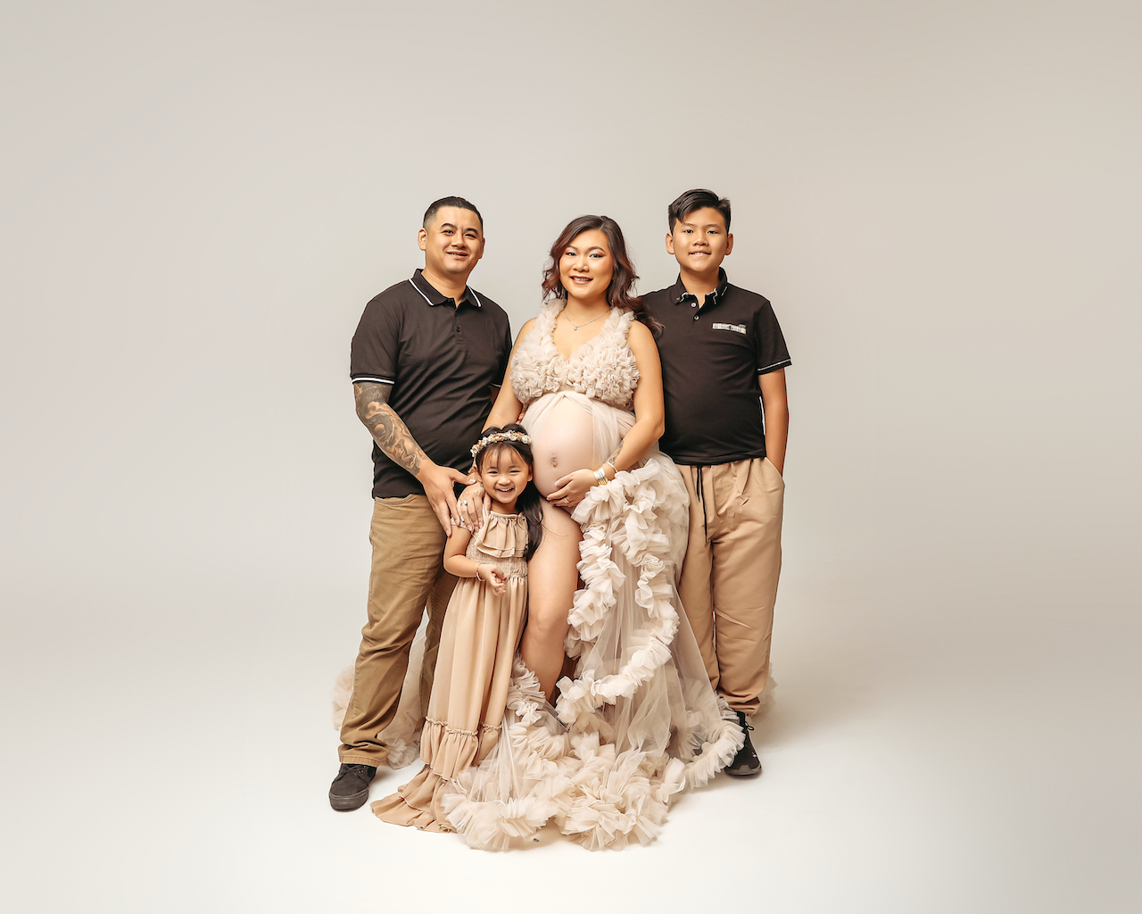 family posing with mother in her materity photos