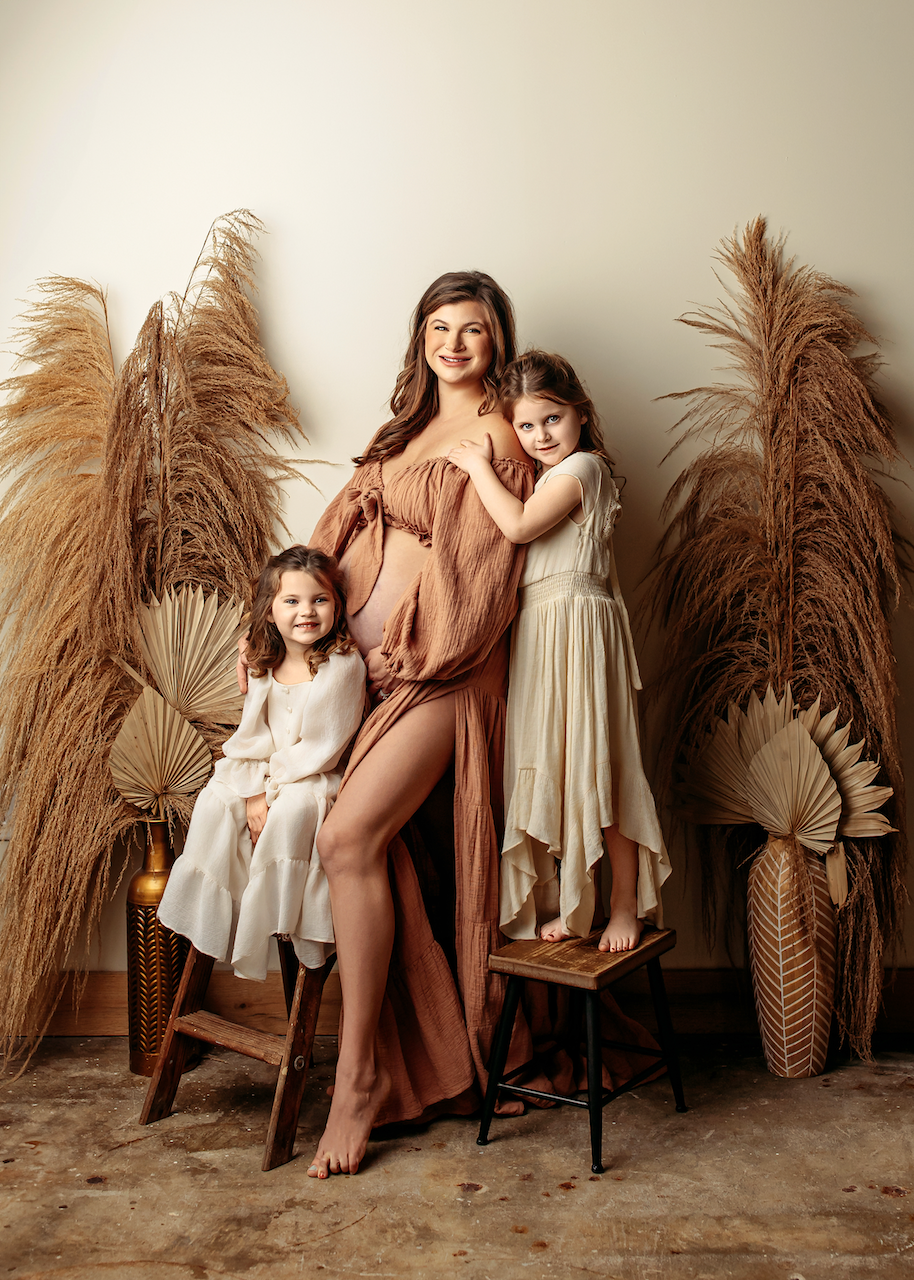 mother and daughters smiling in biege and neutral dresses during mothers photoshoot