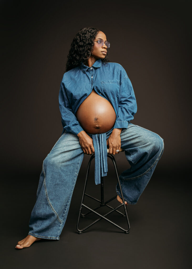women posing with blue jeans and blue top showcasing her belly