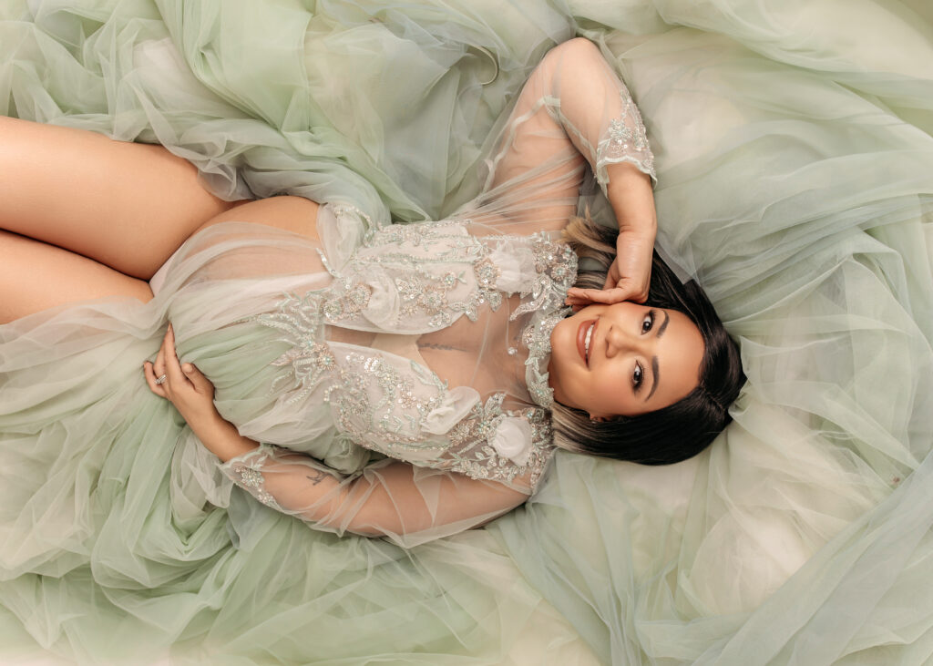Indoor maternity session with mom-to-be in sequin embroidered sage colored dress.