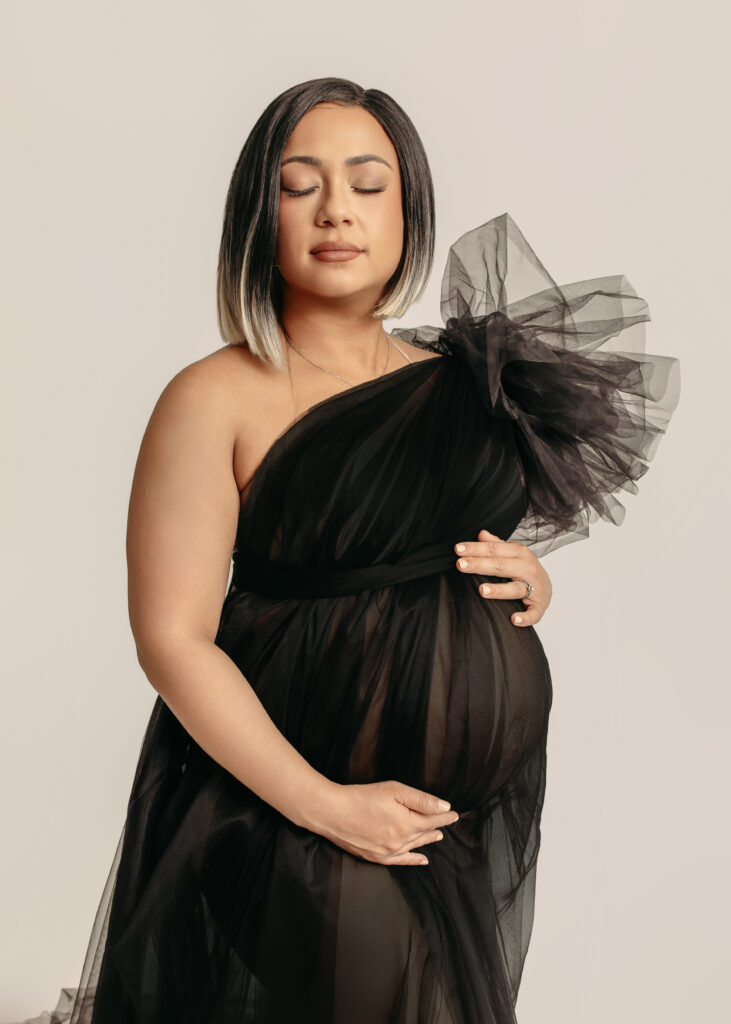 Oklahoma City studio maternity photo with mom in sheer one-shouldered black dress.