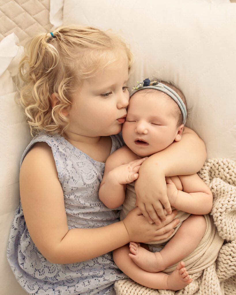 Best photographer in Oklahoma captured sister and newborn baby.